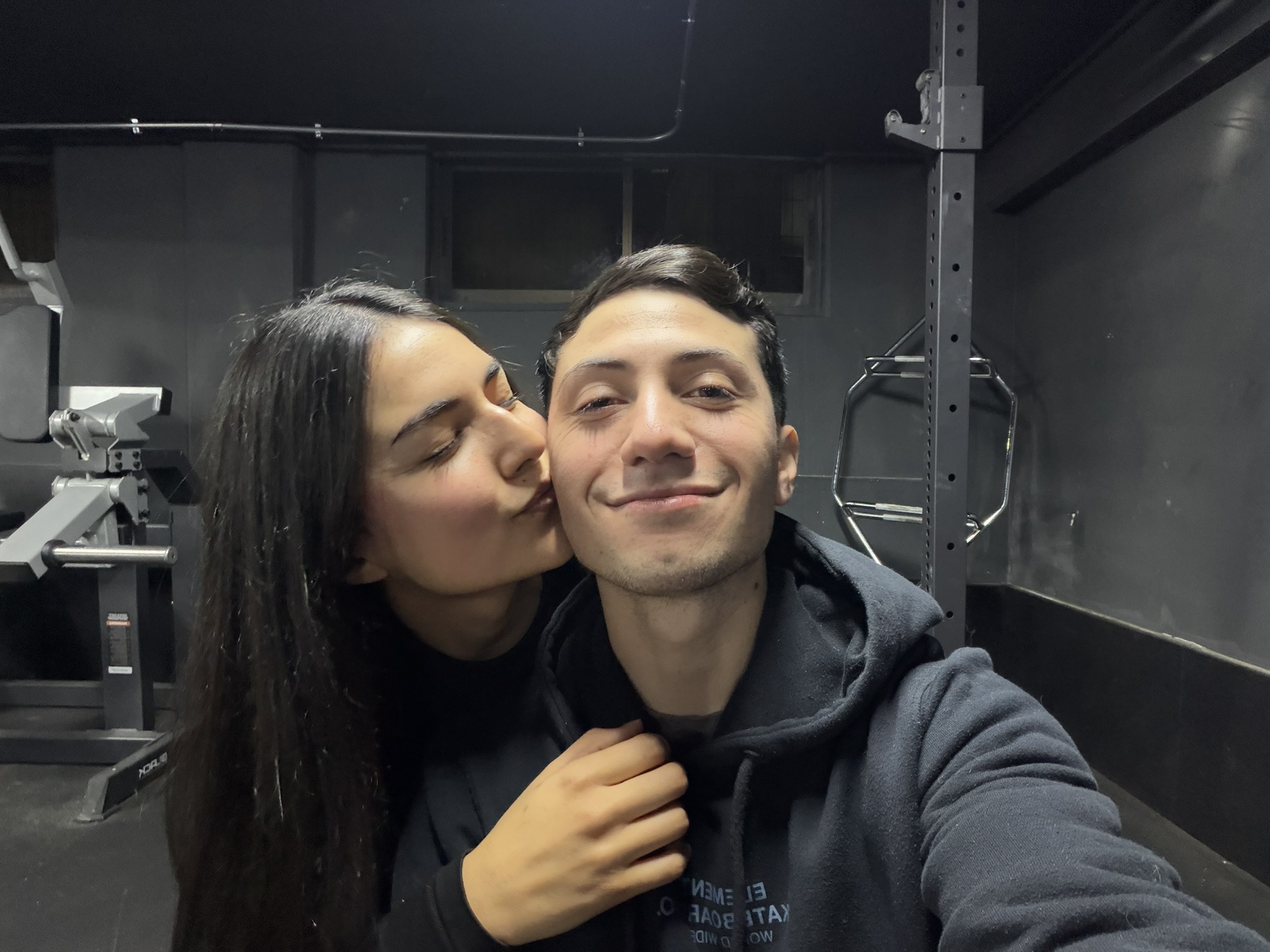 Selfie horizontal de Javier y Sabrina, con Sabrina dando un beso en la mejilla de Javier.